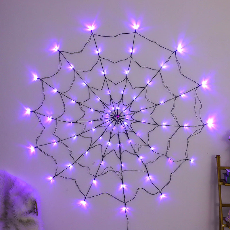 Glowing purple spider web light hanging on a wall